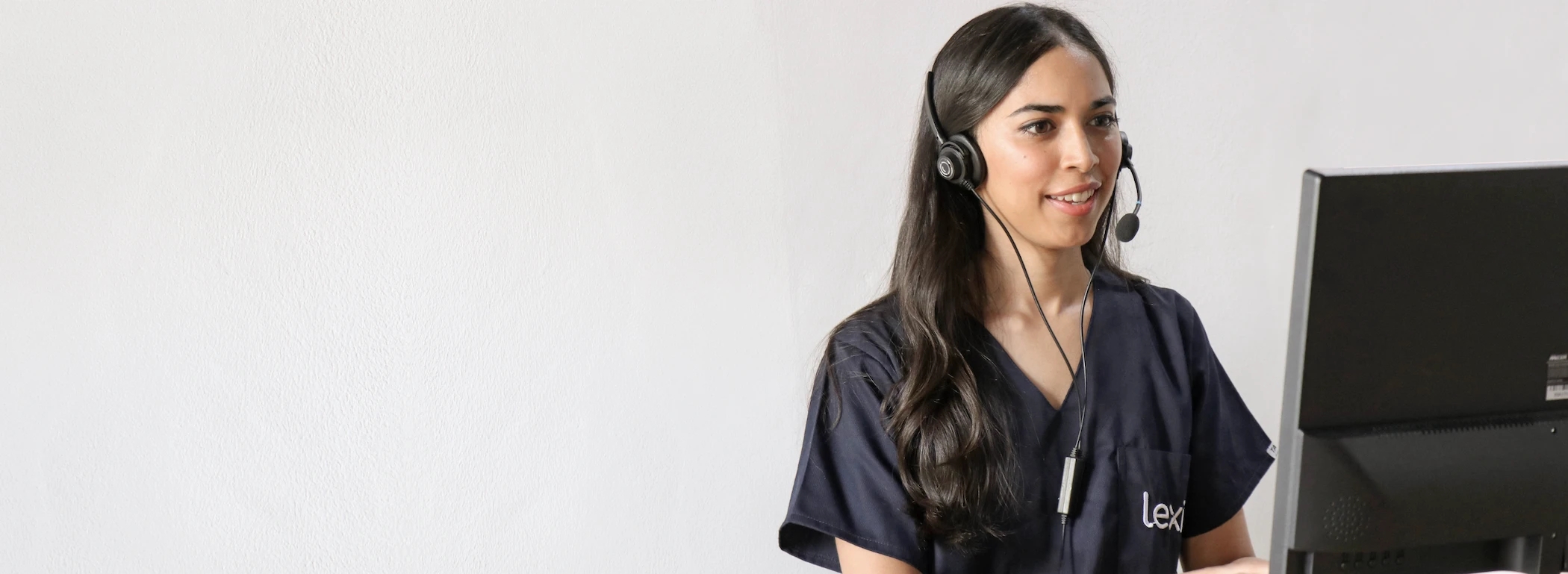 Lexie Expert wearing a headset and on a video call on the computer.