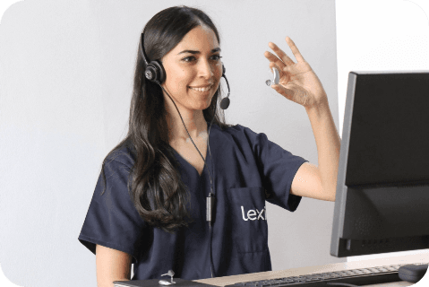 Lexie Expert wearing a headset and holding up a Lexie hearing aid.